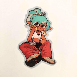 May include: A die-cut sticker featuring a stylized character with teal hair, red eyes, and tan skin. The character wears a white crop top, black fingerless gloves, and baggy red pants, while holding a silver adjustable wrench in one hand.