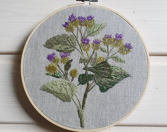 Rustic wall decor in wooden frame of green and purple plant burdock, sustainable art
