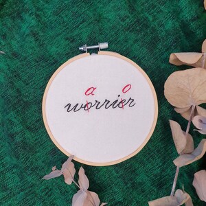 May include: A white ceramic mug with a colorful floral design. The mug features a variety of flowers in shades of pink, purple, and yellow, with green leaves. The handle is also white.