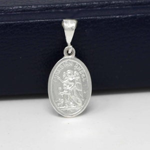 May include: Silver pendant featuring a guardian angel with the words "Guardian Angel" inscribed around the oval-shaped charm.