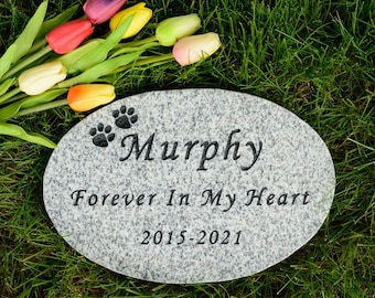 May include: Oval granite pet memorial stone with the name "Murphy", paw prints, and the inscription "Forever In My Heart 2015-2021". Colorful tulips rest on the grass beside the stone.