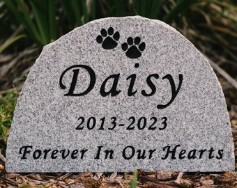 May include: A gray granite pet memorial stone with the inscription "Daisy 2013-2023 Forever In Our Hearts" and two paw prints.