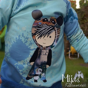 Op de afbeelding: Een lichtblauwe hoodie met een grafische print van een cartoonfiguur met een pandahoed. Het figuur draagt een zwart jack en houdt een panda vast. De tekst "only sta u India" is zichtbaar op het shirt van het figuur.