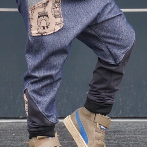 Puede incluir: Un ni&ntilde;o con pantalones de mezclilla azul con un bolsillo estampado en marr&oacute;n y negro y zapatillas altas marrones con detalles azules.