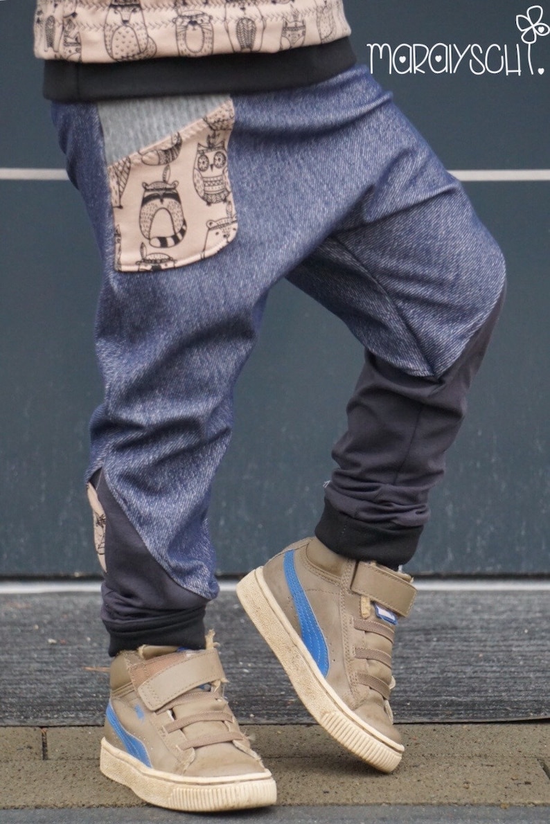 Puede incluir: Un ni&ntilde;o con pantalones de mezclilla azul con un bolsillo estampado en marr&oacute;n y negro y zapatillas altas marrones con detalles azules.