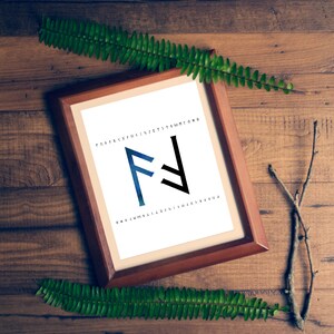 May include: A framed print of the Futhark rune "Fehu" in a blue and black watercolor style. The rune is surrounded by the Futhark alphabet in black text.