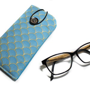 May include: A blue and gold patterned glasses case with a button closure and a pair of black framed glasses with a wooden temple.