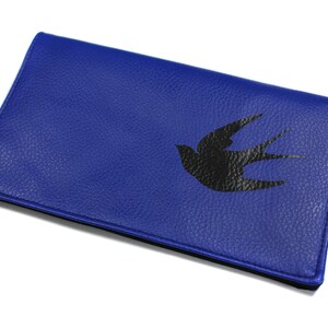 May include: A blue leather wallet with a black silhouette of a bird printed on the front.