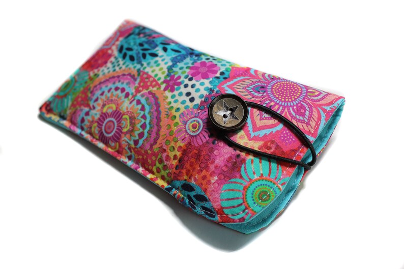 May include: A colorful floral patterned glasses case with a turquoise blue border and a star-shaped button closure.