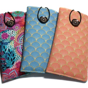 May include: Three different patterned fabric eyeglass cases with a black elastic strap and a star-shaped button closure. The cases are in shades of pink, blue, and orange.