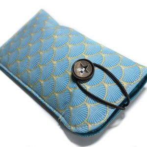 May include: A blue and gold patterned eyeglasses case with a star-shaped button closure and a black strap.