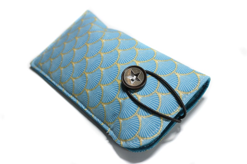 May include: A blue and gold patterned eyeglasses case with a star-shaped button closure and a black strap.