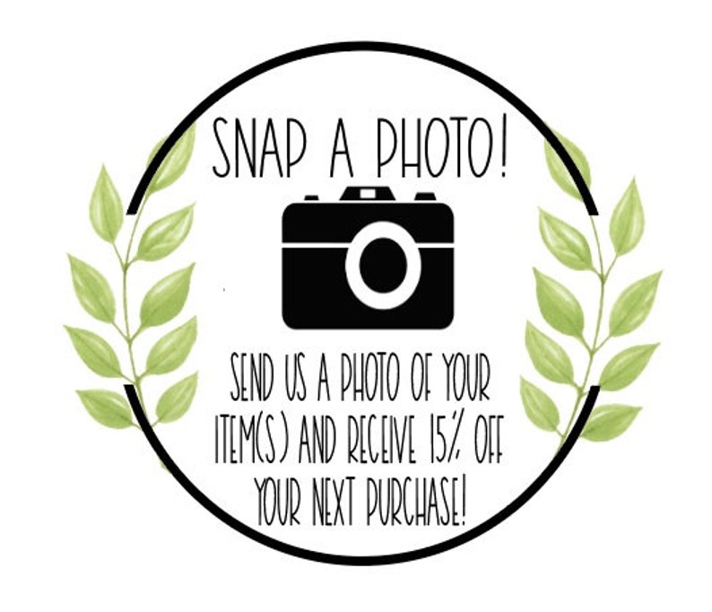 May include: A black and white illustration of a camera with green leafy branches on either side. The text reads "SNAP A PHOTO! SEND US A PHOTO OF YOUR ITEM(S) AND RECEIVE 15% OFF YOUR NEXT PURCHASE!"