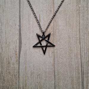 May include: A black metal necklace with a pentagram pendant.
