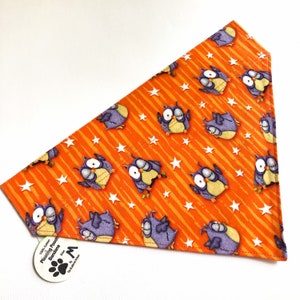 May include: Orange bandana with a pattern of owls and white stars. The bandana is made of 100% cotton and is available in size M.