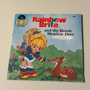May include: A vintage Rainbow Brite book and record set featuring a colourful illustration of Rainbow Brite and a deer. The book is titled "Rainbow Brite and the Brook Meadow Deer".