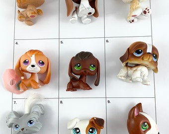 May include: Nine different plastic toy dogs in various poses and colours. The dogs are arranged in a grid on a white background. The dogs are all small and have large eyes.