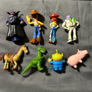 Pu&ograve; includere: Una collezione di figurine dei personaggi di Toy Story, tra cui Woody, Buzz Lightyear, Jessie e altri. Le figure sono dai colori vivaci e realizzate in plastica. I personaggi sono in varie pose d'azione.