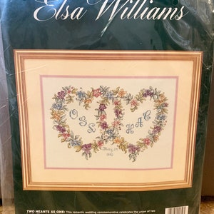 May include: A counted cross stitch kit featuring a floral heart design with the names "OGS" and "Jeff" and the date "May 24, 1992". The kit includes 100% cotton floss, a needle, alphabet and numerical charts, and complete instructions. The finished size is 14 inches by 10 inches.