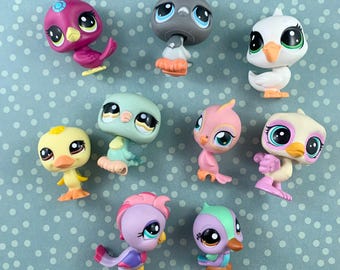 Può includere: Una collezione di piccole figurine di uccelli colorati con grandi occhi. Gli uccelli sono in vari colori, tra cui rosa, giallo, blu e verde. Ogni uccello ha un design e una posa unici, creando un'estetica giocosa e stravagante.