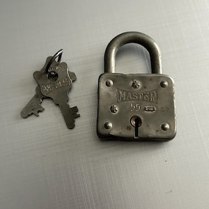 May include: A vintage silver padlock with a key. The padlock has the word "MASTER" embossed on the front, along with the numbers "5" and "37".