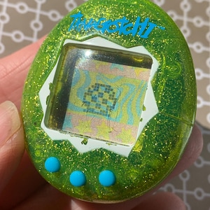 Llavero verde brillante, raro, del juego electrónico Tamagotchi de Bandai. Sin manual ni caja.