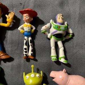 Pu&ograve; includere: Una collezione di figurine dei personaggi di Toy Story, tra cui Woody, Jessie, Buzz Lightyear, un alieno e Hamm il maiale. Le figurine sono dai colori vivaci e realizzate in plastica, con dettagli e pose.