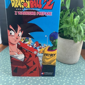 May include: A Dragon Ball Z DVD box set featuring Goku and other characters. The box is blue with the Dragon Ball Z logo and the text "Z Warriors Prepare." The box also includes the Funimation Productions Inc. logo.