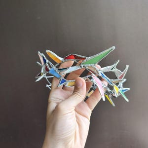May include: A circular crown constructed from multiple small, angular pieces of multicolored stained glass held together by silver-toned metal solder. The glass shards feature various hues including red, green, blue, yellow, and pink, creating a mosaic effect.