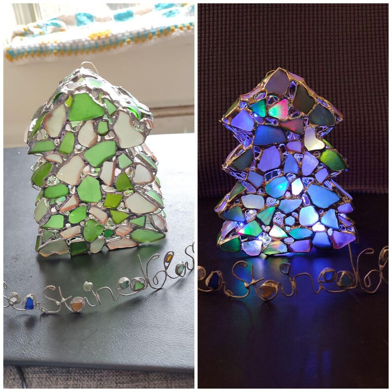 K&ouml;nnte beinhalten: Zwei Weihnachtsb&auml;ume aus Glasmosaik, einer mit wei&szlig;en Lichtern und der andere ohne. Beide B&auml;ume sind aus Meerglas gefertigt und haben eine Drahtbasis mit der Aufschrift "Sea Glass".