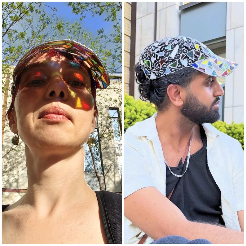 May include: Two people wearing colorful, patterned baseball caps. The caps have a stained-glass effect, with vibrant colors and geometric designs. The caps are worn outdoors in natural light, creating a play of light and shadow.
