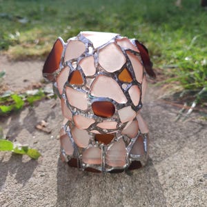May include: A small, white, glass sculpture of a dog made from many pieces of glass. The sculpture is made in the style of stained glass, with the pieces of glass held together by silver metal.