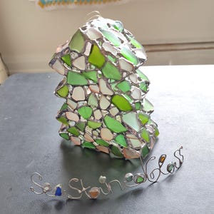 K&ouml;nnte beinhalten: Ein gr&uuml;ner und wei&szlig;er Glasmosaik-Anh&auml;nger in Form eines Baumes mit den Worten "Sea Glass" in Draht darunter.