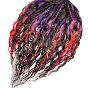 May include: A set of long, wavy hair extensions with black, red, and purple strands. The extensions are arranged in a loose, flowing style.