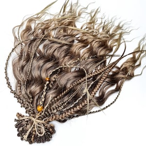 May include: A set of brown and blonde human hair extensions with braids and beads. The extensions are wavy and have a natural look.