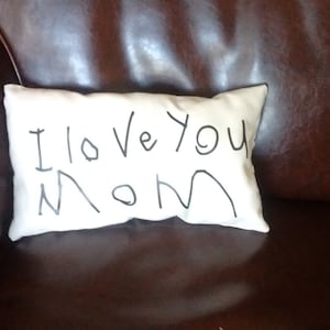 May include: A white pillow with the words "I love you Mom" written in black marker.