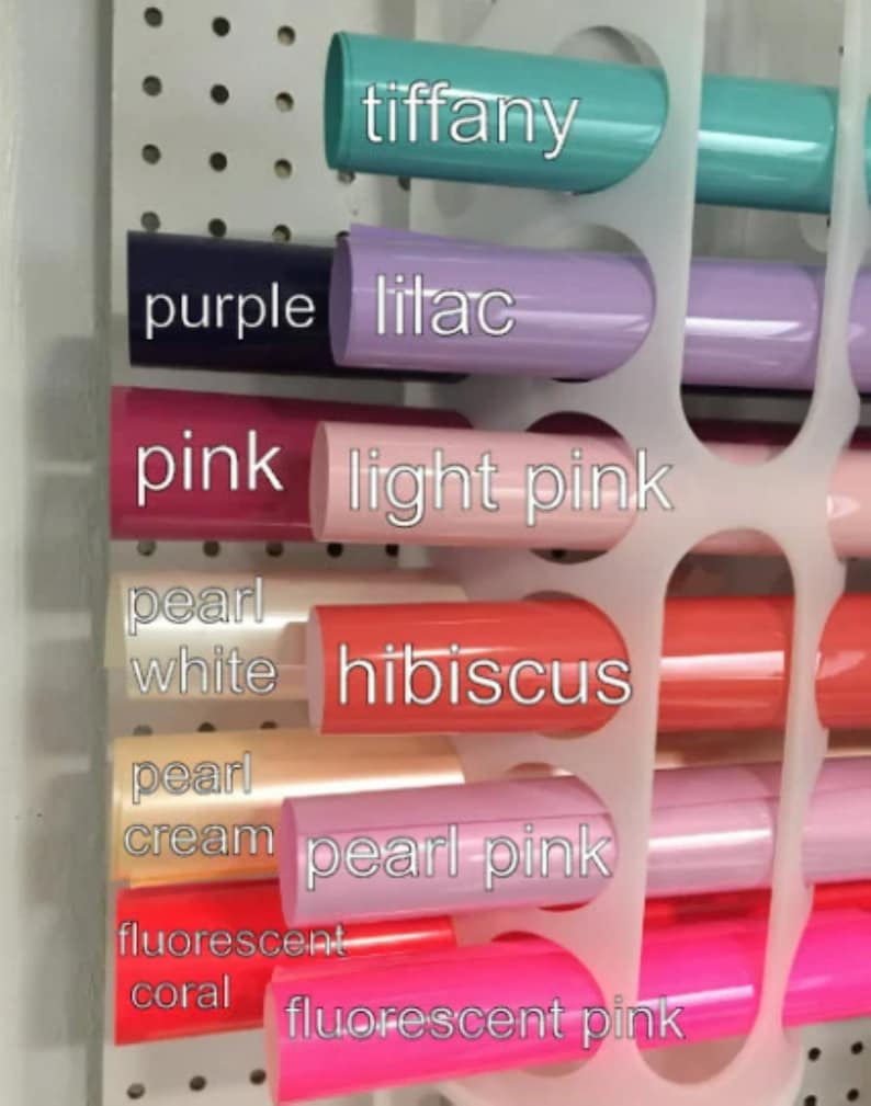 May include: A close-up of a variety of colored vinyl rolls, including tiffany, purple, lilac, pink, light pink, pearl white, hibiscus, pearl cream, pearl pink, fluorescent coral, and fluorescent pink.