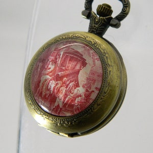 Batteriebetriebene Taschenuhr, ihre Gravur unter Cabochon und ihr Schlüssel.