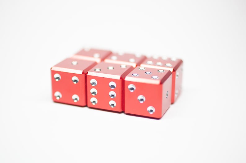 Puede incluir: Un conjunto de seis dados rojos con puntos blancos. Los dados est&aacute;n dispuestos en forma rectangular.