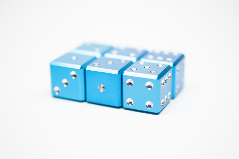 Puede incluir: Un conjunto de ocho dados azules con puntos plateados. Los dados est&aacute;n dispuestos en dos filas de cuatro.