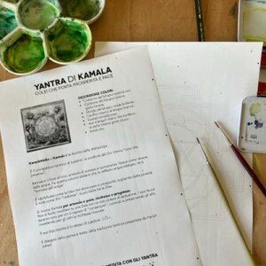 May include: A printable worksheet with instructions for coloring a Yantra of Kamala, a symbol of prosperity and peace. The worksheet includes a description of the Yantra and its meaning, along with a color guide. The text reads "Yantra di Kamala Colei che porta prosperita e pace" and "Disegna, colora e medita con gli Yantra Yoga e Creativita www.souquiloni.com".