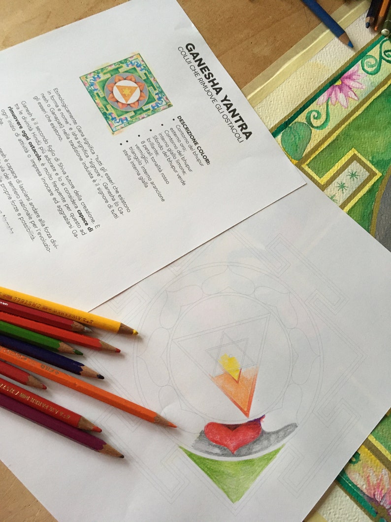 May include: A printable coloring page featuring a Ganesha Yantra, a geometric design believed to remove obstacles. The page includes instructions for coloring the design with specific colors, including gold, yellow, orange, red, green, and white.