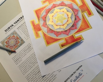 May include: A detailed drawing of a Surya Yantra, a geometric mandala representing the sun, with a gold and red color scheme. The drawing is on white paper and includes instructions for coloring the yantra.