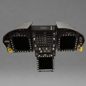 May include: A black Moza flight simulator cockpit panel featuring three dark display screens, a central numeric keypad, multiple rotary knobs, toggle switches, and a yellow emergency jettison button on the left side with a yellow safety switch on the right.