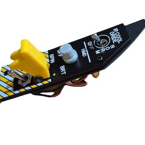 以下が含まれることがあります： 黄色と白のストライプの黒いコントロールパネルで、さまざまなスイッチとノブが付いています。パネルには、「SPIN」、「BRT」、「OFF」、「HMD」、「ON」、「M」、「IR COOL」、「RIDE」のラベルが付いています。