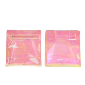 May include: Two iridescent pink stand-up pouches with zipper closures. The pouches are made of clear plastic with a holographic finish. The text "PULL TAB TO OPEN" is printed on the top of the pouch on the left.