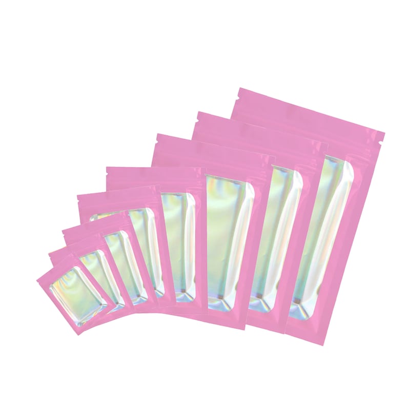 May include: A set of seven pink iridescent zippered pouches of varying sizes. The pouches are made of a shiny, metallic material and have a clear window on the front.
