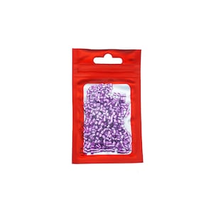 Pu&ograve; includere: Un sacchetto di plastica rosso richiudibile con una finestra trasparente che mostra una grande quantit&agrave; di piccole perline metalliche viola.
