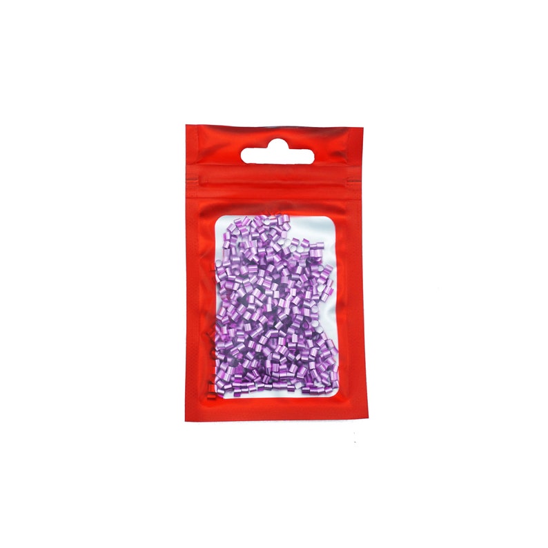 Pu&ograve; includere: Un sacchetto di plastica rosso richiudibile con una finestra trasparente che mostra una grande quantit&agrave; di piccole perline metalliche viola.
