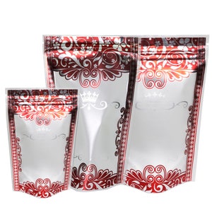 May include: Three silver and red stand-up pouches with a zipper closure. The pouches have a white background with a silver crown and a red and silver floral design.